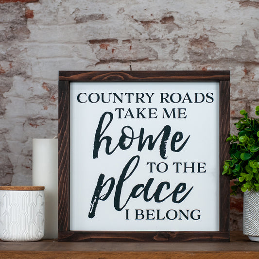 country roads take me home to the place i belong  ~ wood sign