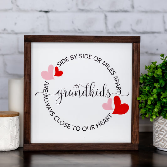 side by side or miles apart grandkids are always close to our heart  ~ wood sign